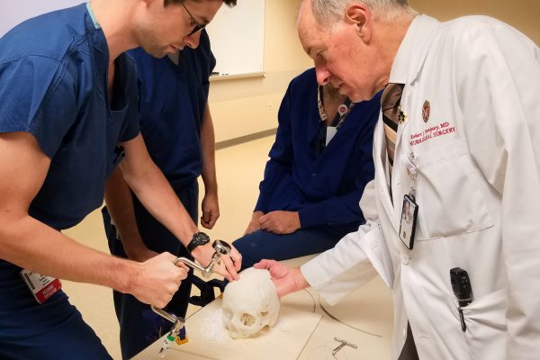 Robert J. Dempsey, MD (right) gives a hands-on surgical demonstration to our PGY 1 resident, Niall Buckley, MD.