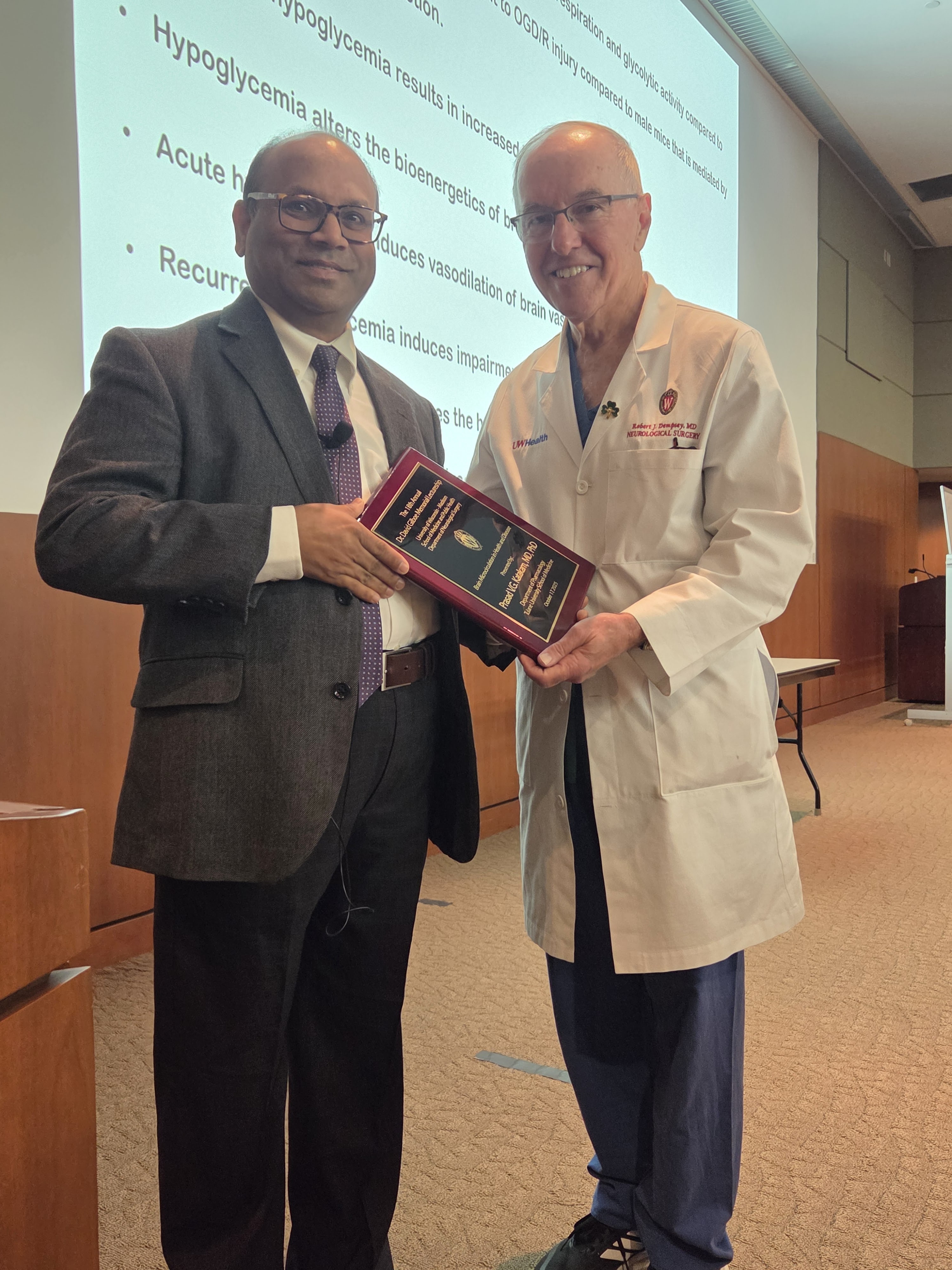 Dr. Dempsey presents Dr. Katakam with an award